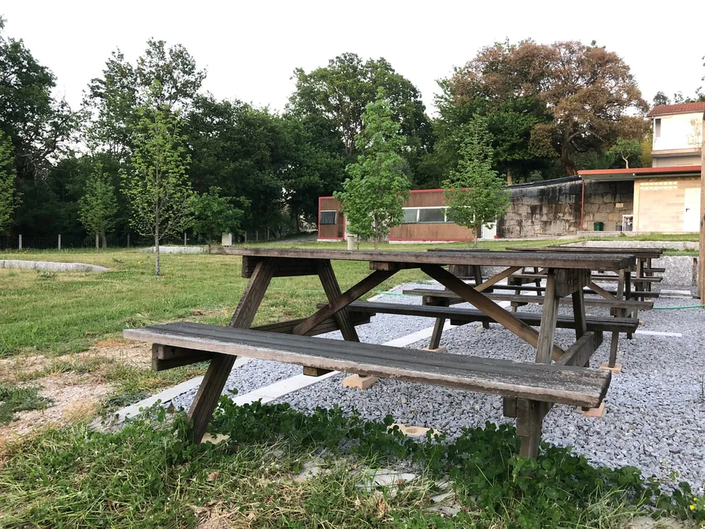 Mesas de picnic en parcela con vistas a la montaña del Camping Garfepark, Póvoa de Lanhoso (Braga)