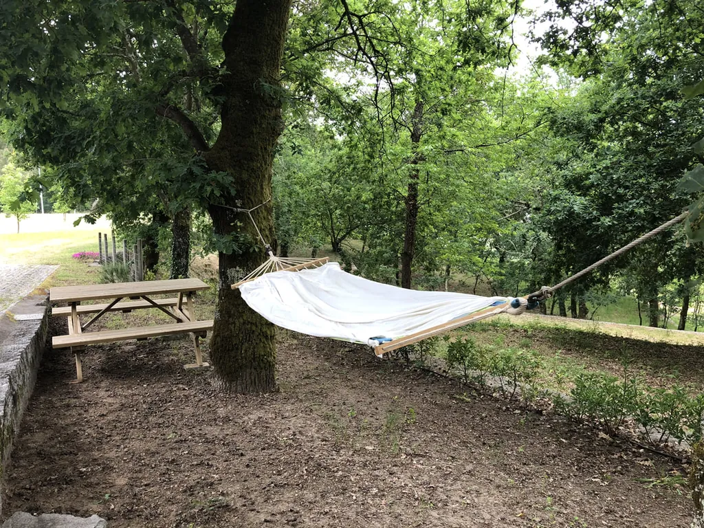 Parcela con hamaca y mesa de picnic entre árboles del Camping Garfepark, Póvoa de Lanhoso (Braga)