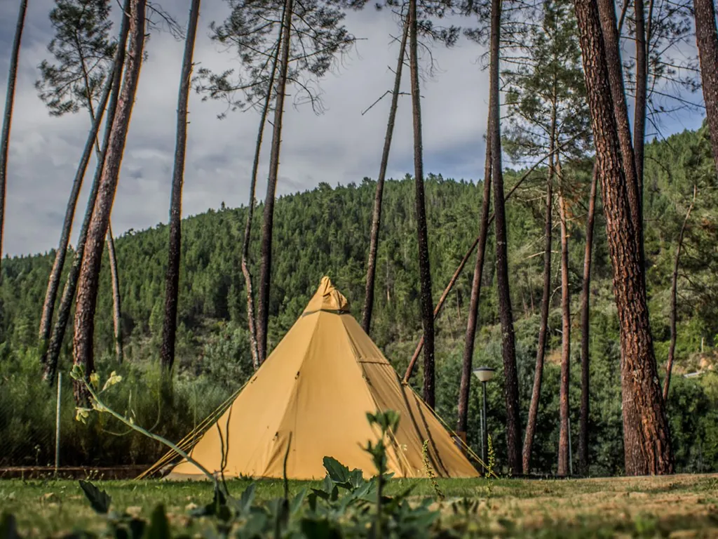 Tipi amarillo en montaña boscosa del Camping Xisto Camping, Pampilhosa da Serra (Coimbra)