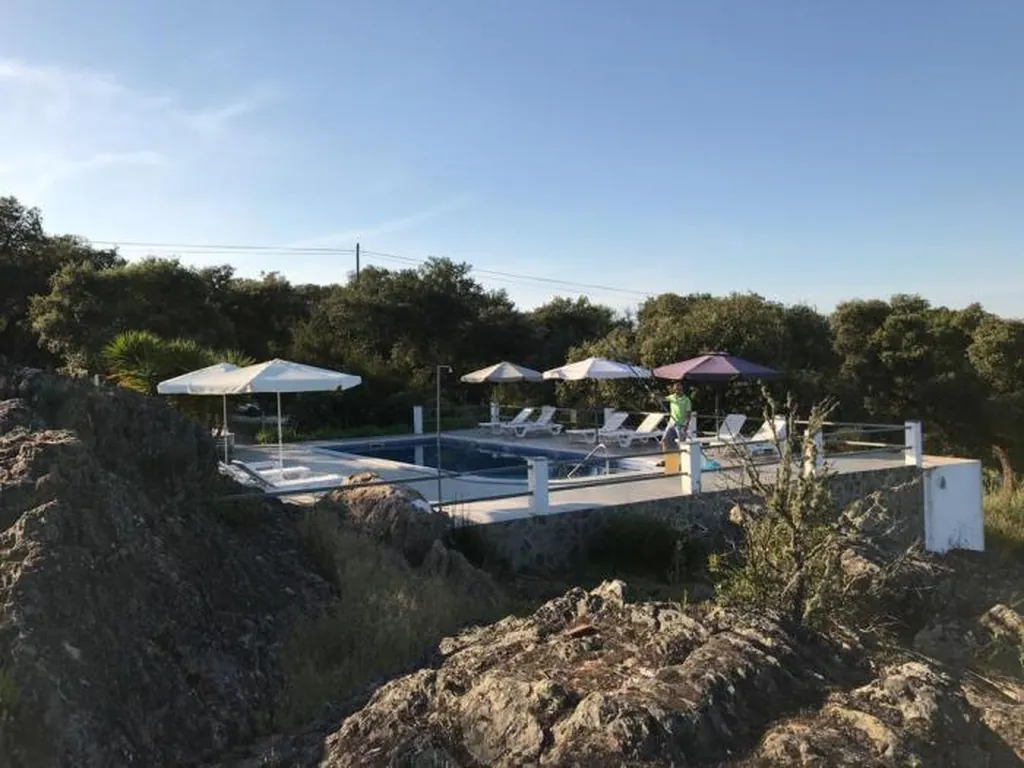 Piscina con sombrillas y tumbonas en entorno natural del Camping Alentejo, Arraiolos (Évora)