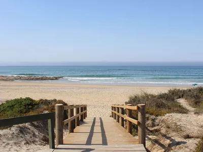 Playa junto al mar con pasarela de madera del Camping Urban Art by Campigir, Peniche (Leiria)