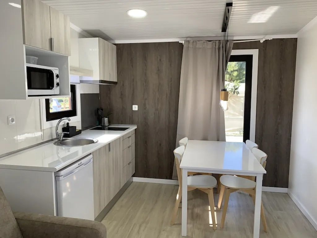 Mobil-home con cocina equipada y zona de comedor del Camping Urban Art by Campigir, Peniche (Leiria)