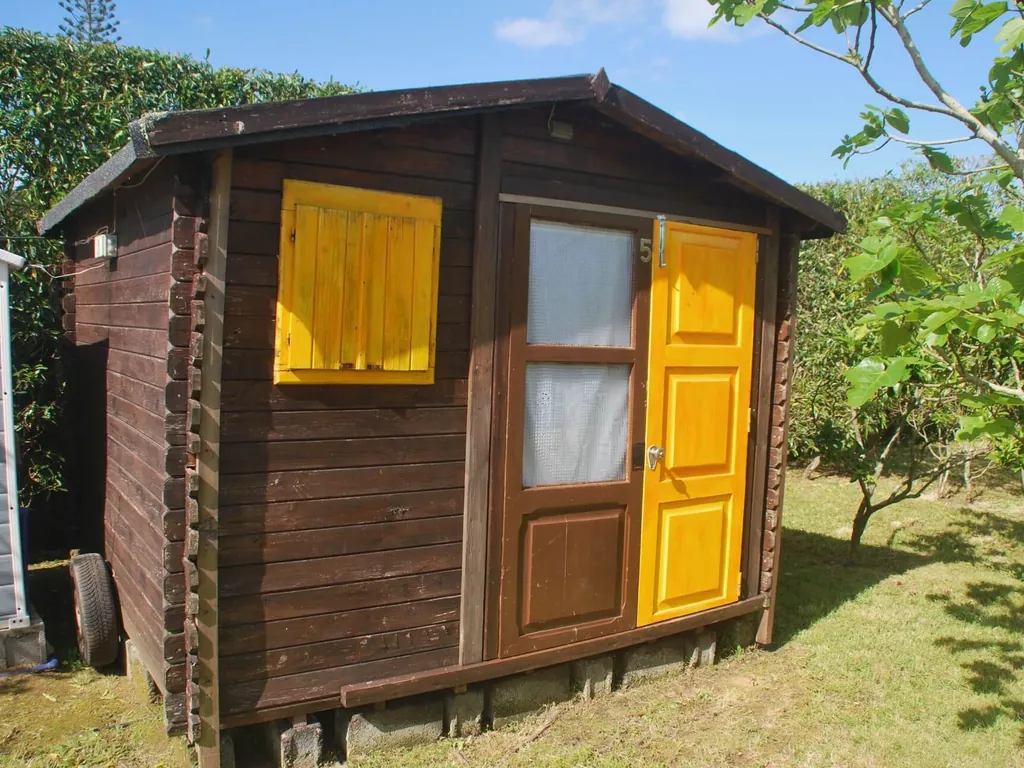Cabaña de madera con puerta amarilla del Camping Quinta das Laranjeiras, Ribeira Grande (Açores)
