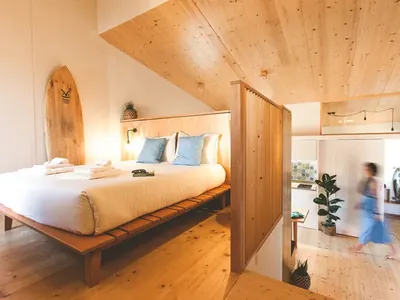 Glamping interior con cama doble y techo de madera del Camping Bukubaki Eco Surf Resort, Peniche (Leiria)