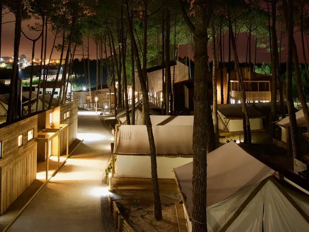 Glamping entre árboles iluminado al atardecer del Camping Bukubaki Eco Surf Resort, Peniche (Leiria)