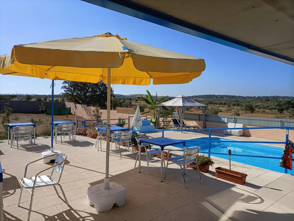 Piscina con zona de sombrillas y tumbonas del Camping Terra Nua - Parque de Campismo e Caravanismo Naturista, Aljustrel (Beja)