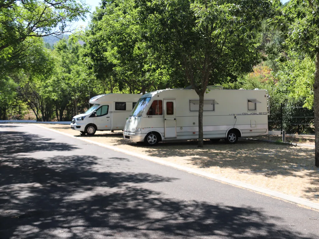 Mobil-home en parcela arbolada con montaña al fondo del Camping Parque de Campismo da Aldeia Ruiva, Proença-a-Nova (Castelo Branco)