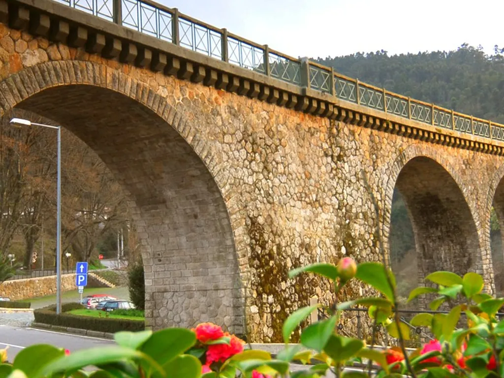 Entorno junto al río con puente de piedra del Camping Parque de Campismo e Caravanismo de Vouzela, Vouzela (Viseu)
