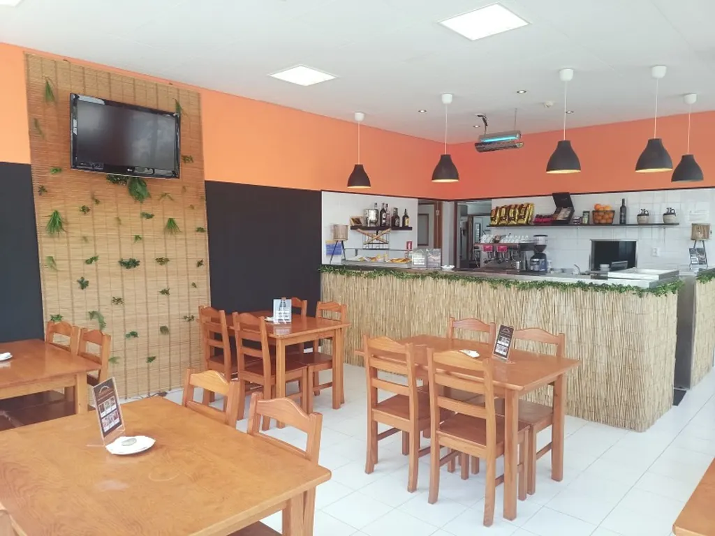 Restaurante bar con mesas de madera y barra del Camping Orbitur Canidelo, Vila Nova de Gaia (Porto)