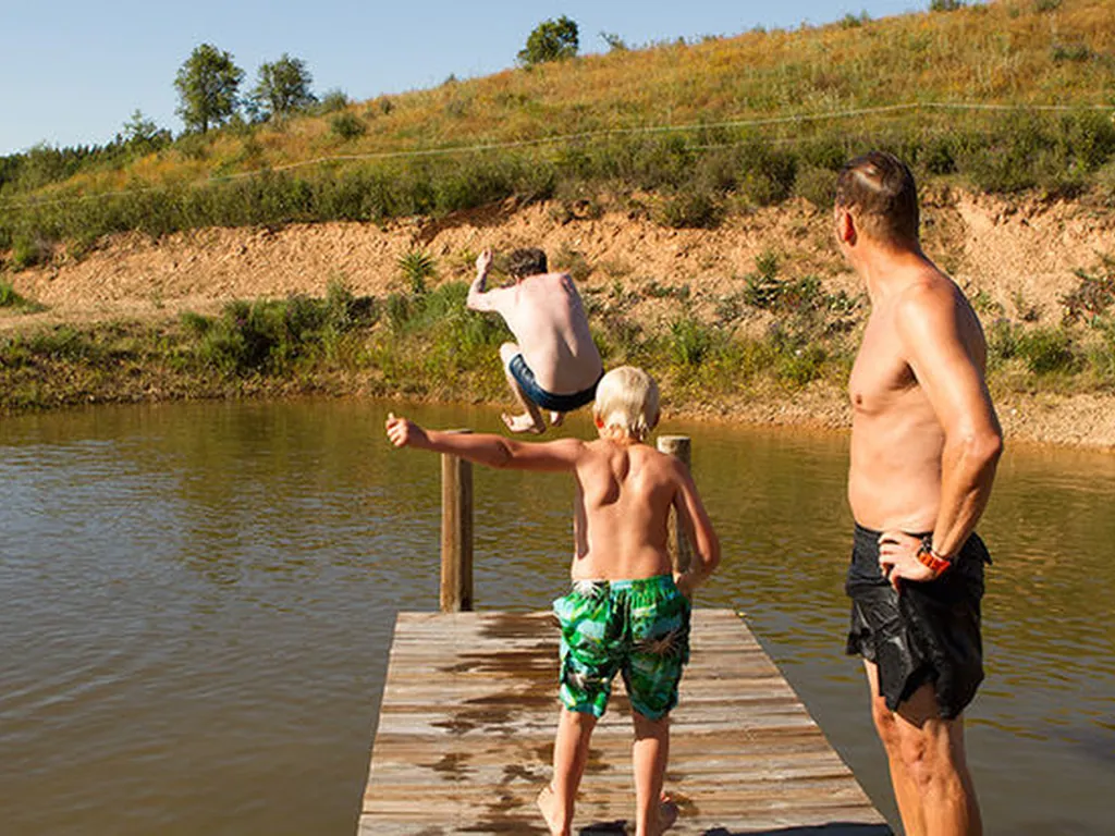 Río con muelle y niños bañándose del Camping Casas Novas da Palmeira, São Teotónio (Beja)