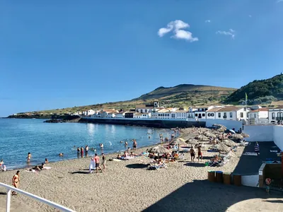 Playa junto al mar con casas blancas y montaña del Camping Parque de Campismo do Pinheiro, Santa Cruz da Graciosa (Açores)