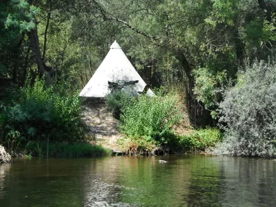 Tipi junto al río rodeado de vegetación del Camping Quinta do Rio, Canedo de Basto (Braga)