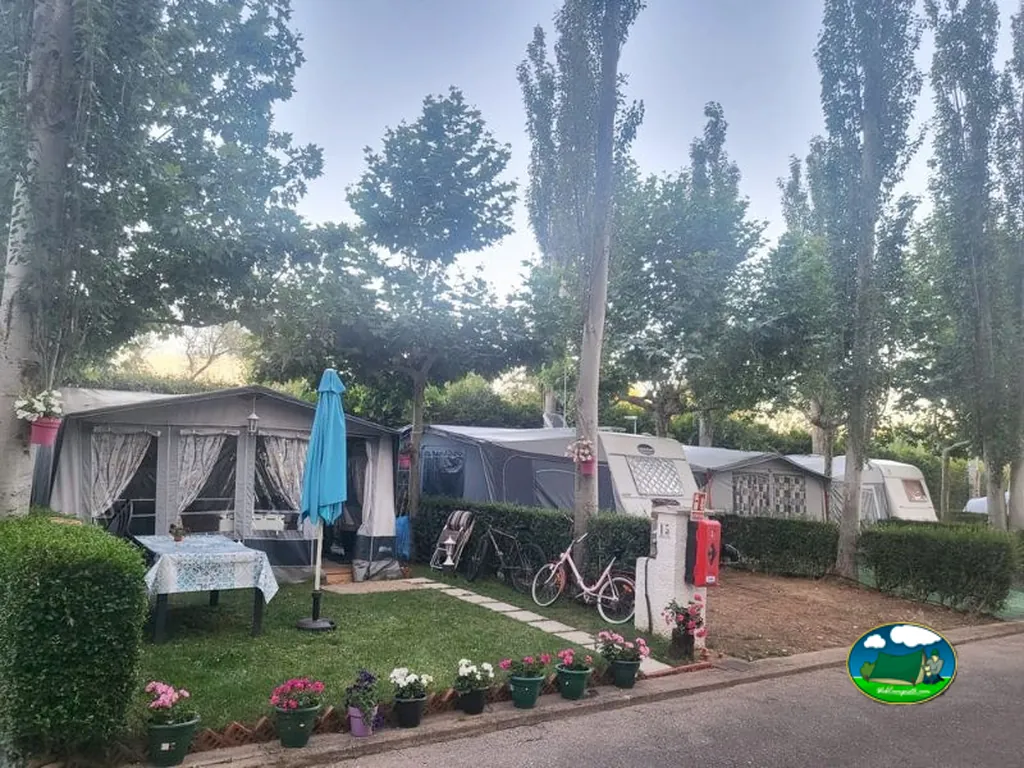 Parcela con caravana y toldo azul del Camping Alkamping, Villarejo de Órbigo (León)
