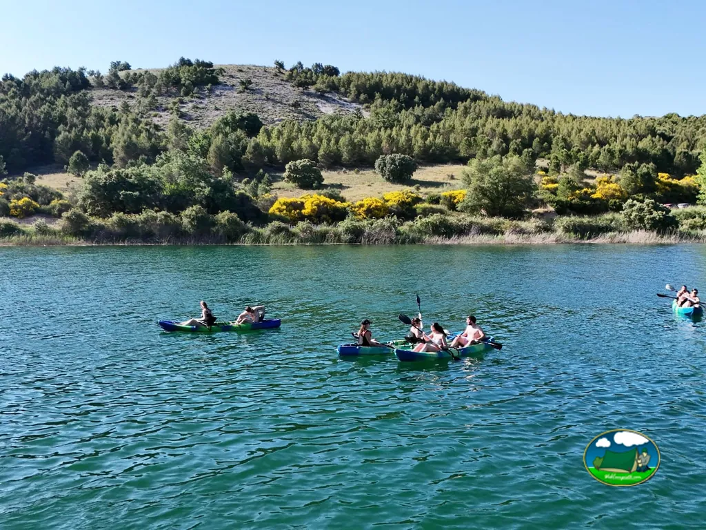 Lago con botes y familias disfrutando, sierra con bosque del Camping Glamping La Bellota, Encinas de Esgueva (Valladolid)