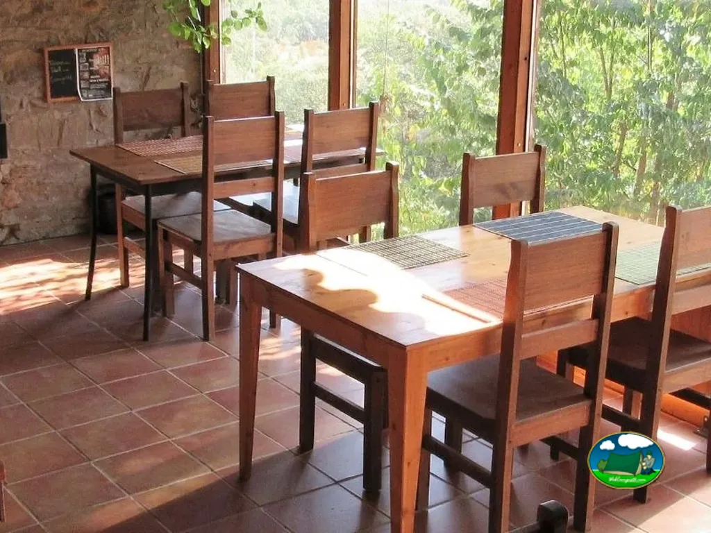 Restaurante con mesas de madera y vistas al bosque del Camping Terra del Congost, Tremp (Lleida)