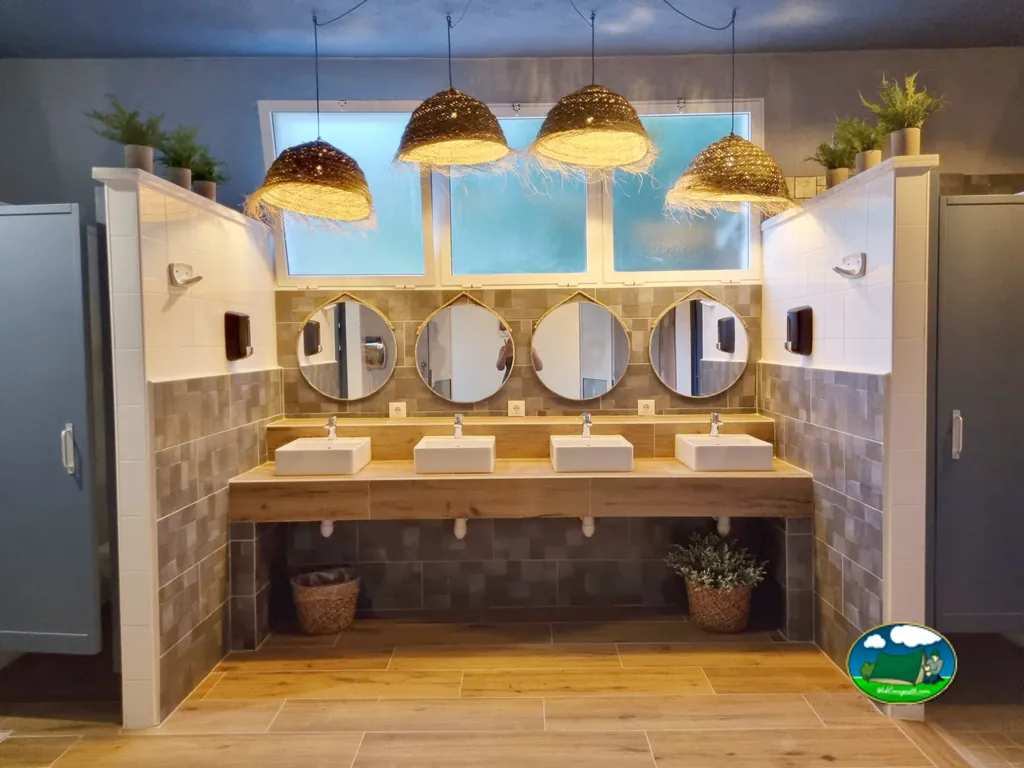 Aseos con 4 lavabos y espejos circulares, iluminación de diseño del Camping Benigembla, Benigembla (Alicante)