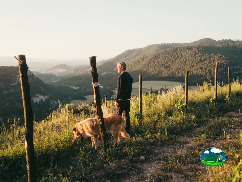 Montaña con vistas al lago, persona con perro en senderismo del Camping Oller del Mas, Manresa (Barcelona)