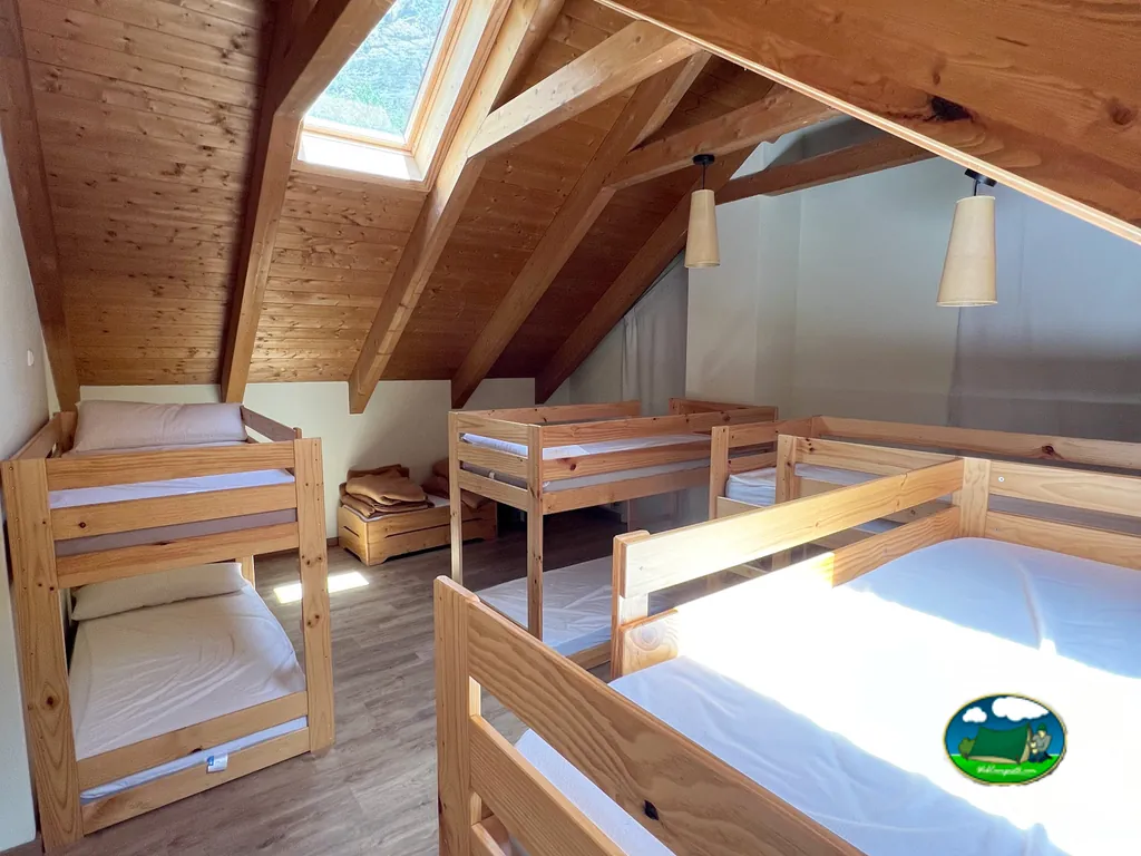 Glamping interior con camas de madera y tragaluces del Camping Riu Gelat, Espot (Lleida)