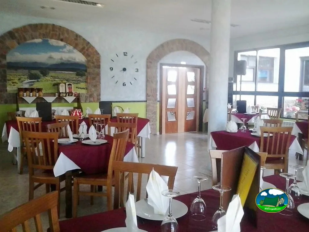 Restaurante bar con mesas redondas y vistas a montaña del Camping Los Molinos, Manzanal de Arriba (Zamora)