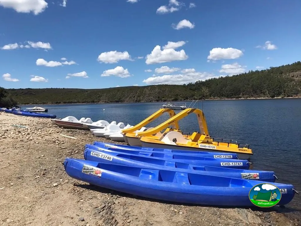 Playa junto al lago con botes y actividades acuáticas del Camping Los Molinos, Manzanal de Arriba (Zamora)