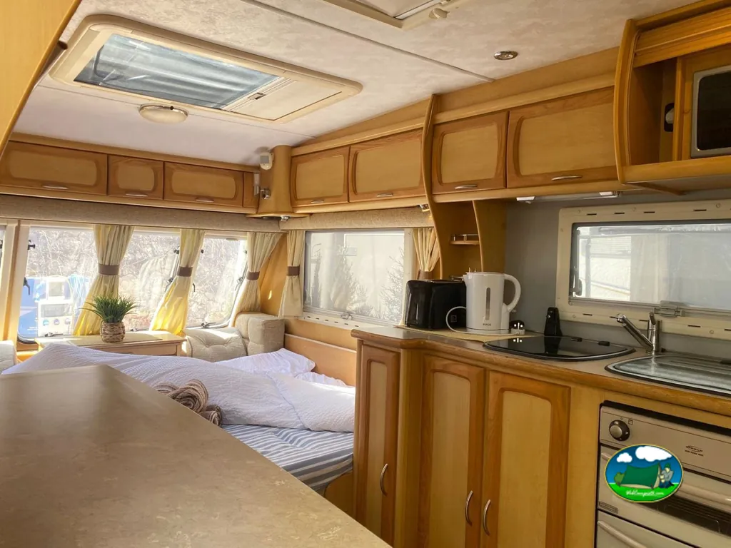Mobil-home interior con cocina equipada y dormitorio del Camping Mediterráneo Camper Area, Calp (Alicante)