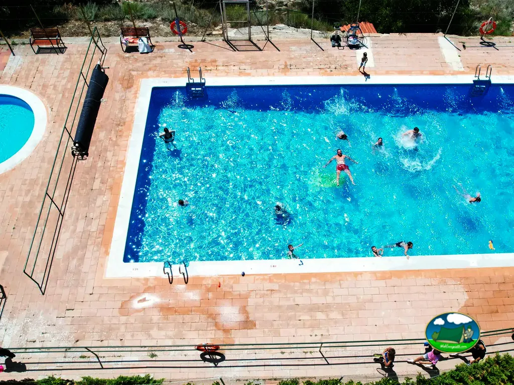 Piscina con bañistas y zona de descanso del Camping Casa Fausto, Formiche Alto (Teruel)