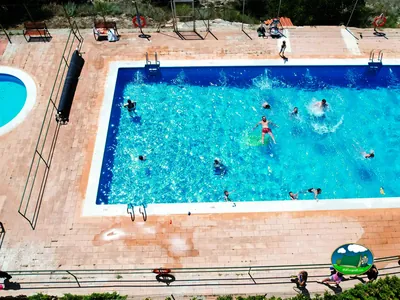 Piscina con bañistas y zona de descanso del Camping Casa Fausto, Formiche Alto (Teruel)