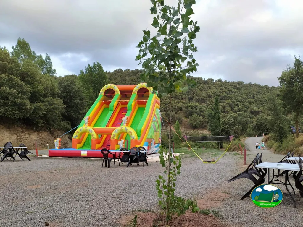 Parque infantil con tobogán inflable y vistas a la montaña del Camping Casa Fausto, Formiche Alto (Teruel)