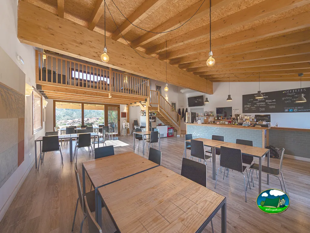 Restaurante bar interior con vigas madera y mezzanina del Camping Beceite, Beceite (Teruel)