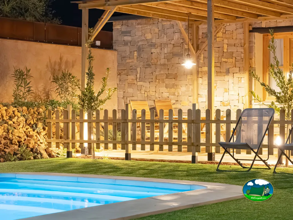 Piscina con bungalow y terraza iluminada del Camping Alma del Cabriel, El Herrumblar (Cuenca)