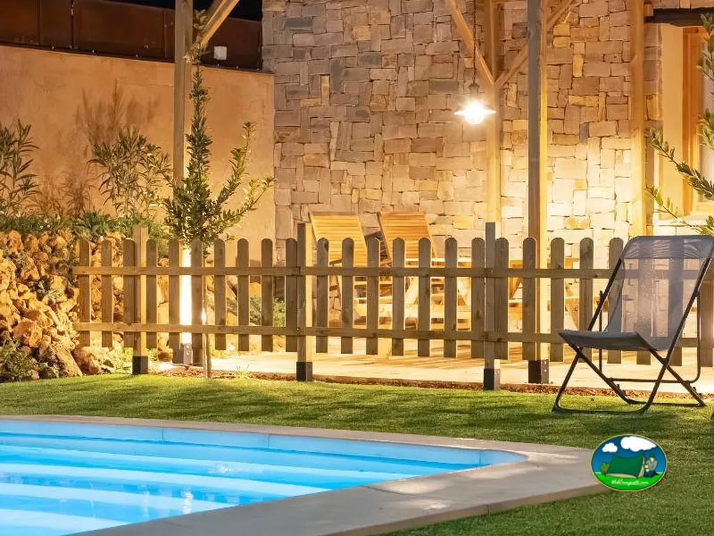 Piscina con zona de relax y bungalow iluminado del Camping Alma del Cabriel, El Herrumblar (Cuenca)
