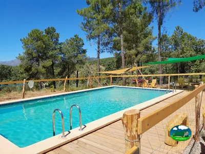 Piscina con vistas a la montaña y sombrillas del Camping El Merino, Villasbuenas de Gata (Cáceres)