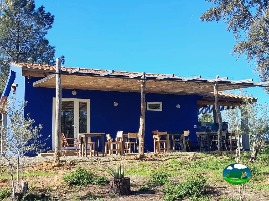 Glamping azul con terraza y sombrilla en entorno natural del Camping El Merino, Villasbuenas de Gata (Cáceres)