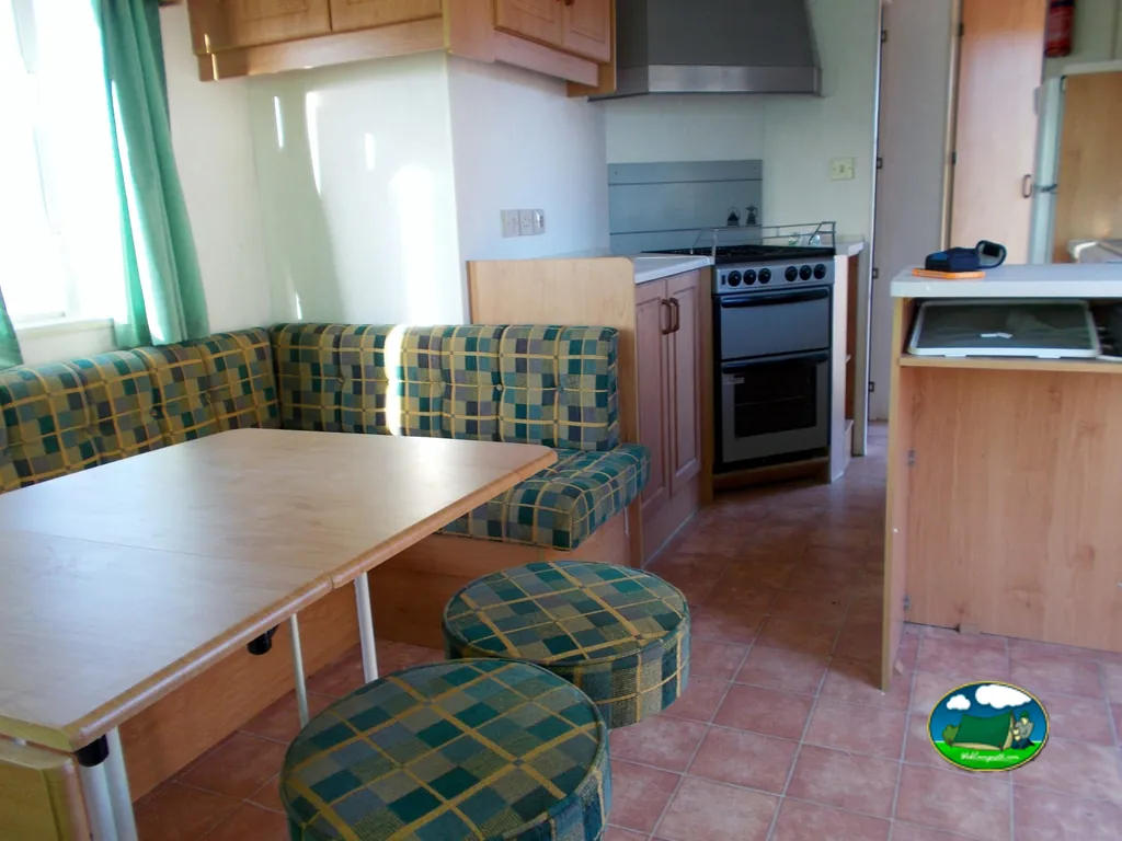 Mobil-home interior con cocina y zona de comedor del Camping Club Los Almendros, Fayón (Zaragoza)