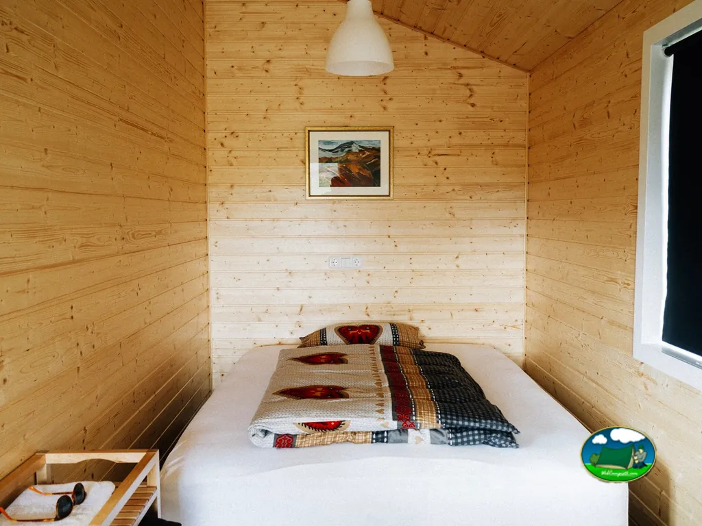 Glamping interior de cabaña de madera con cama doble del Camping Club Los Almendros, Fayón (Zaragoza)