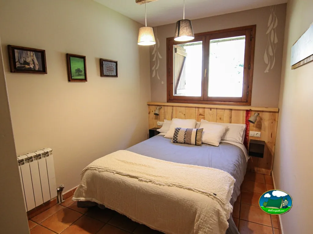 Bungalow interior con cama doble y calefacción del Camping San Nicolás de Bujaruelo, Torla (Huesca)