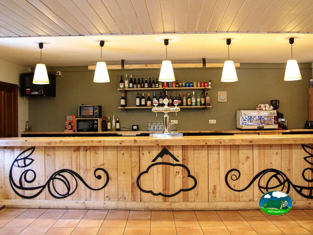 Restaurante bar con barra de madera y botellas del Camping San Nicolás de Bujaruelo, Torla (Huesca)