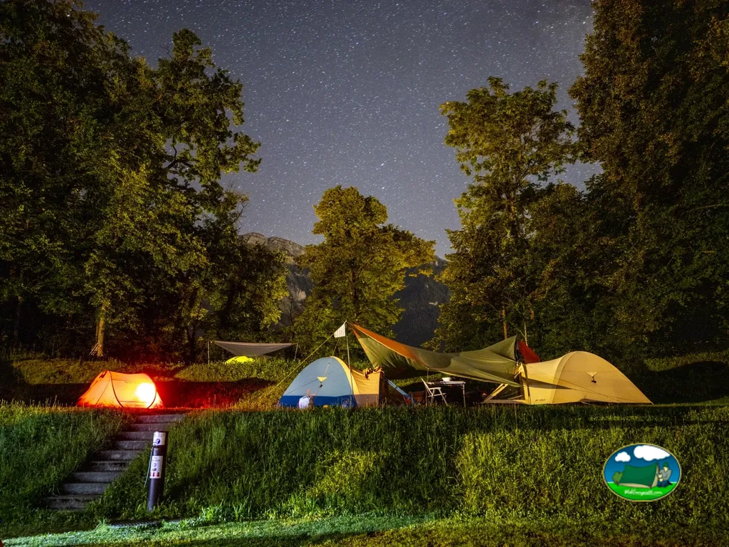 Tienda de acampada nocturna con vistas a la montaña y cielo estrellado del Camping Talacker, Ringgenberg