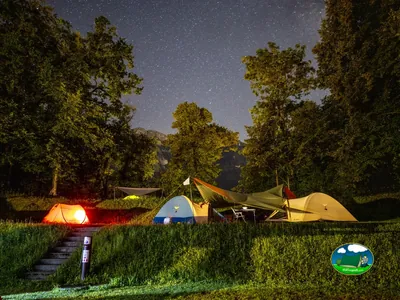 Tienda de acampada nocturna con vistas a la montaña y cielo estrellado del Camping Talacker, Ringgenberg