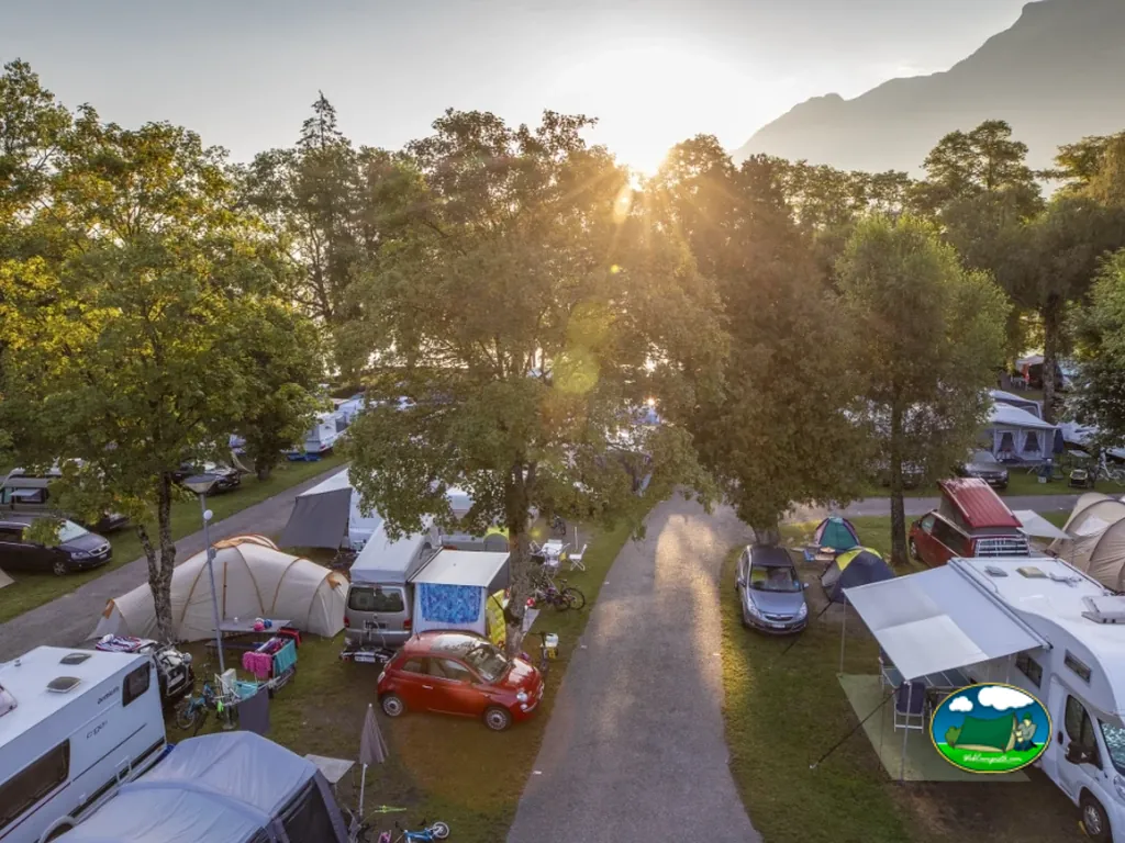 Parcelas con autocaravanas y tiendas de campaña al atardecer con vistas a la montaña del TCS Camping Bönigen - Brienzersee, Bönigen