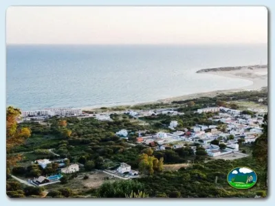 Playa junto al mar con bungalows y vistas aéreas del recinto del Camping Camaleón, Caños de Meca. Barbate (Cádiz)