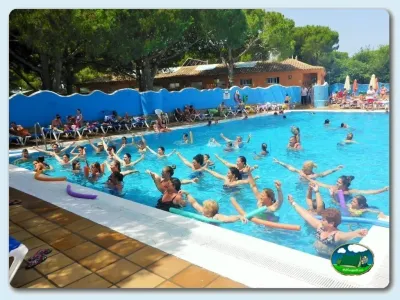 Piscina con clase de aquagym, sombrillas y edificios del Camping Caños de Meca, Barbate (Cádiz)