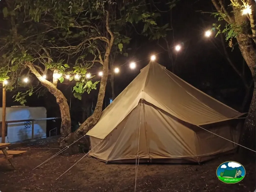 Glamping tipi iluminado entre árboles al atardecer del Camping Medina Sidonia, Medina Sidonia (Cádiz)