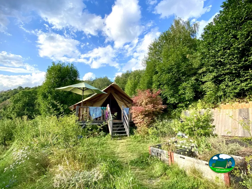 Glamping tienda de acampada con sombrilla en parcela arbolada del Camping Alp Safari Glamping & Camping, Nax (Valais)