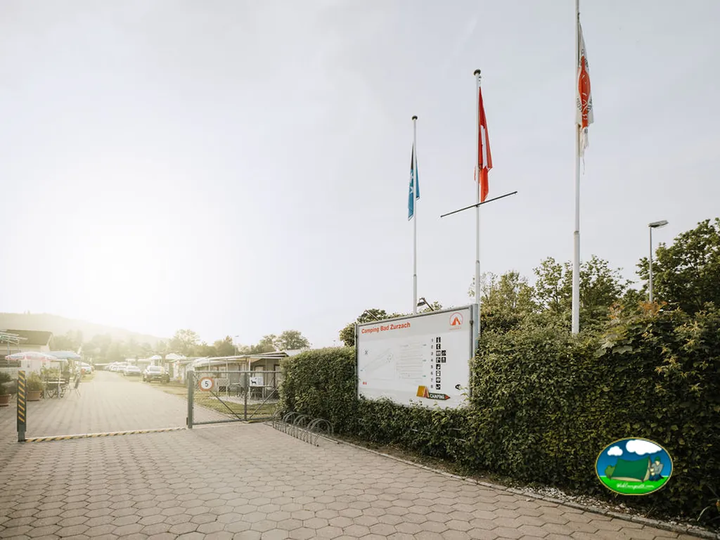 Entrada del recinto con bandera y señalética del Camping & Caravanclub Bad Zurzach (Oberfeld), Bad Zurzach (Argovia)