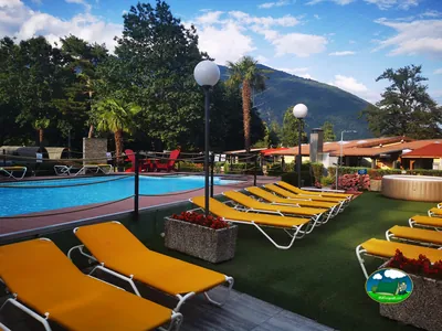 Piscina con vistas a la montaña, tumbonas y jacuzzi del Camping Melezza, Losone (Tesino)