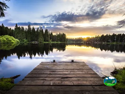 Lago con embarcadero y montaña al atardecer del Camping Vieux-Pont, Goumois (Jura)
