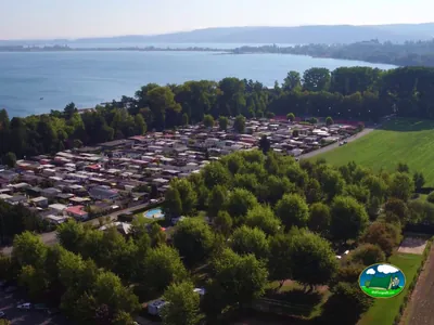 Lago con vistas a la montaña, parcelas y mobil-homes del Camping des Pêches, Le Landeron (Neuchâtel)