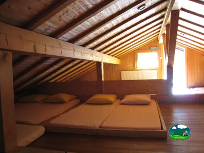 Cabaña interior con cama doble y literas del Camping La Moubra, Montana (Valais)