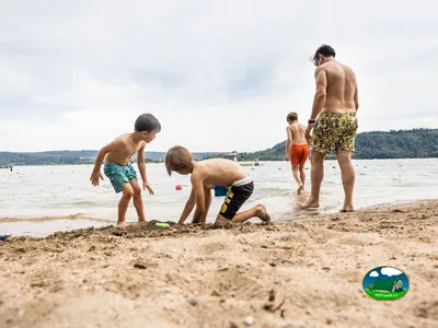 Playa junto al lago, niños jugando en la arena del Camping La Plage, La Neuveville (Berna)
